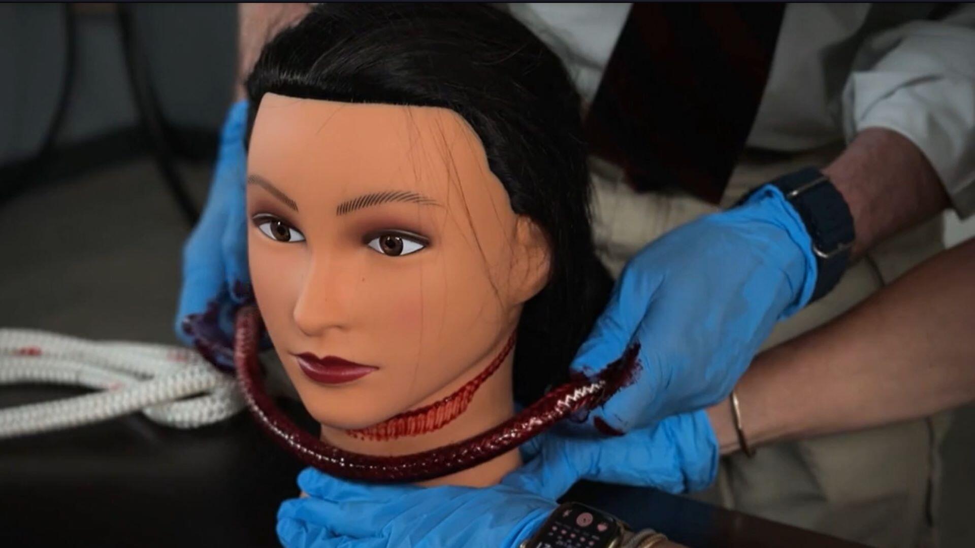 Using a mannequin and red paint, Dr. Bill Smock demonstrates the pattern of ligature marks found on Joanna Hunter's neck during her autopsy. / Credit: CBS News