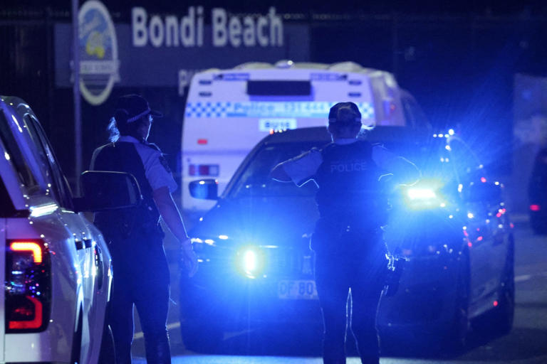 David Gray/AFP via Getty Images - PHOTO: Police walk on a street after a shooting incident at Bondi Beach in Sydney on Dec. 14, 2025.