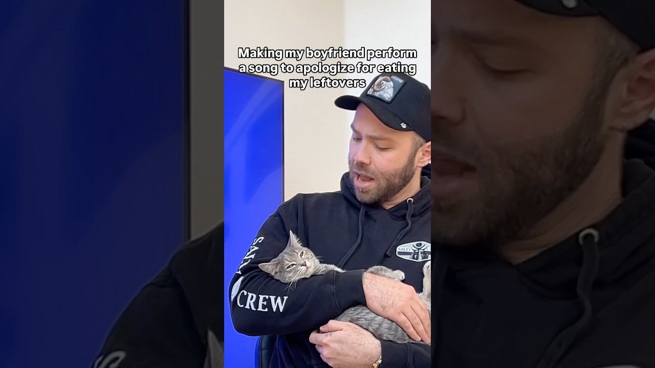 Helpful cat helps man sing a song to his girlfriend