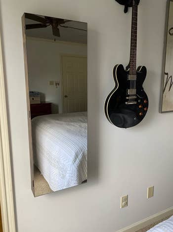 Bedroom wall with the jewelry organized mounted and closed to show mirror