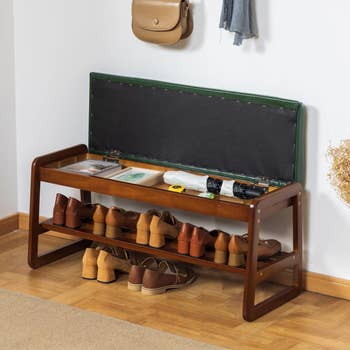 same wooden bench with cushion flipped up to show storage beneath