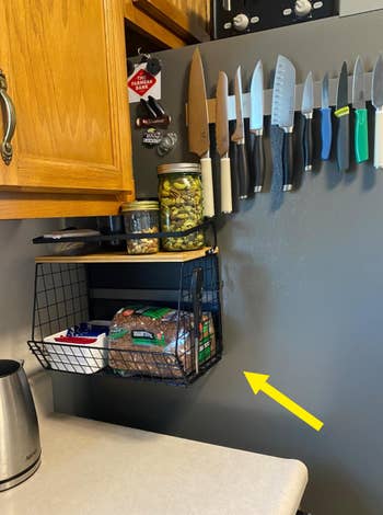reviewer image of magnetic shelf attached to fridge holding bread and other kitchen essentials, with clear counter and a magnetic knife strip visible