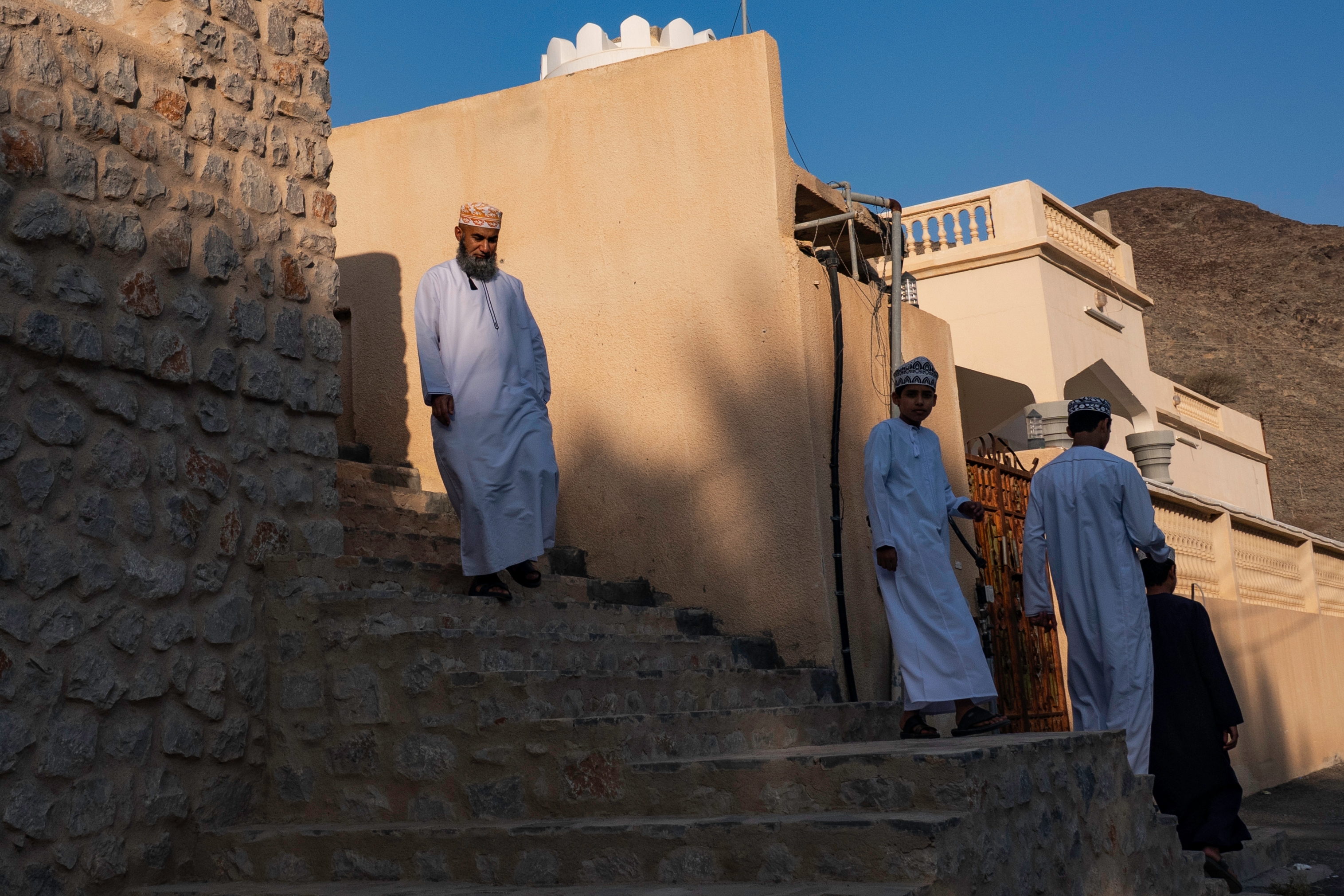 Yousuf al-Mawaly, an Islamic studies teacher at a local middle school, makes his way home after an afternoon prayer at local mosque in Samad al-Shan, Oman.