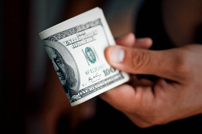 The man gives a pack of money