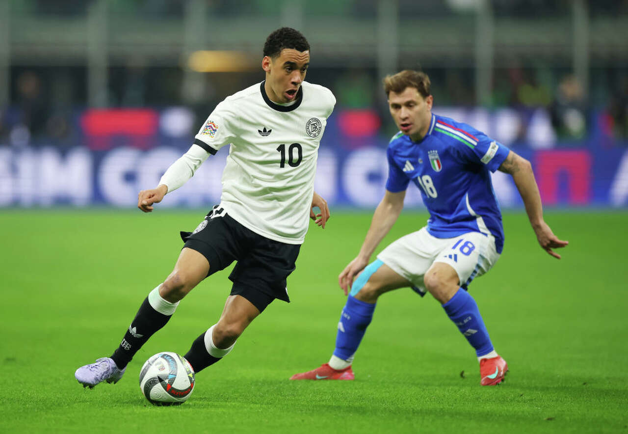 Jamal Musiala of Germany runs with the ball whilst under pressure from Nicolo Barella of Italy during the UEFA Nations League quarterfinal leg one match between Italy and Germany at Stadio San Siro on March 20, 2025 in Milan, Italy. (Alex Grimm/Getty Images)