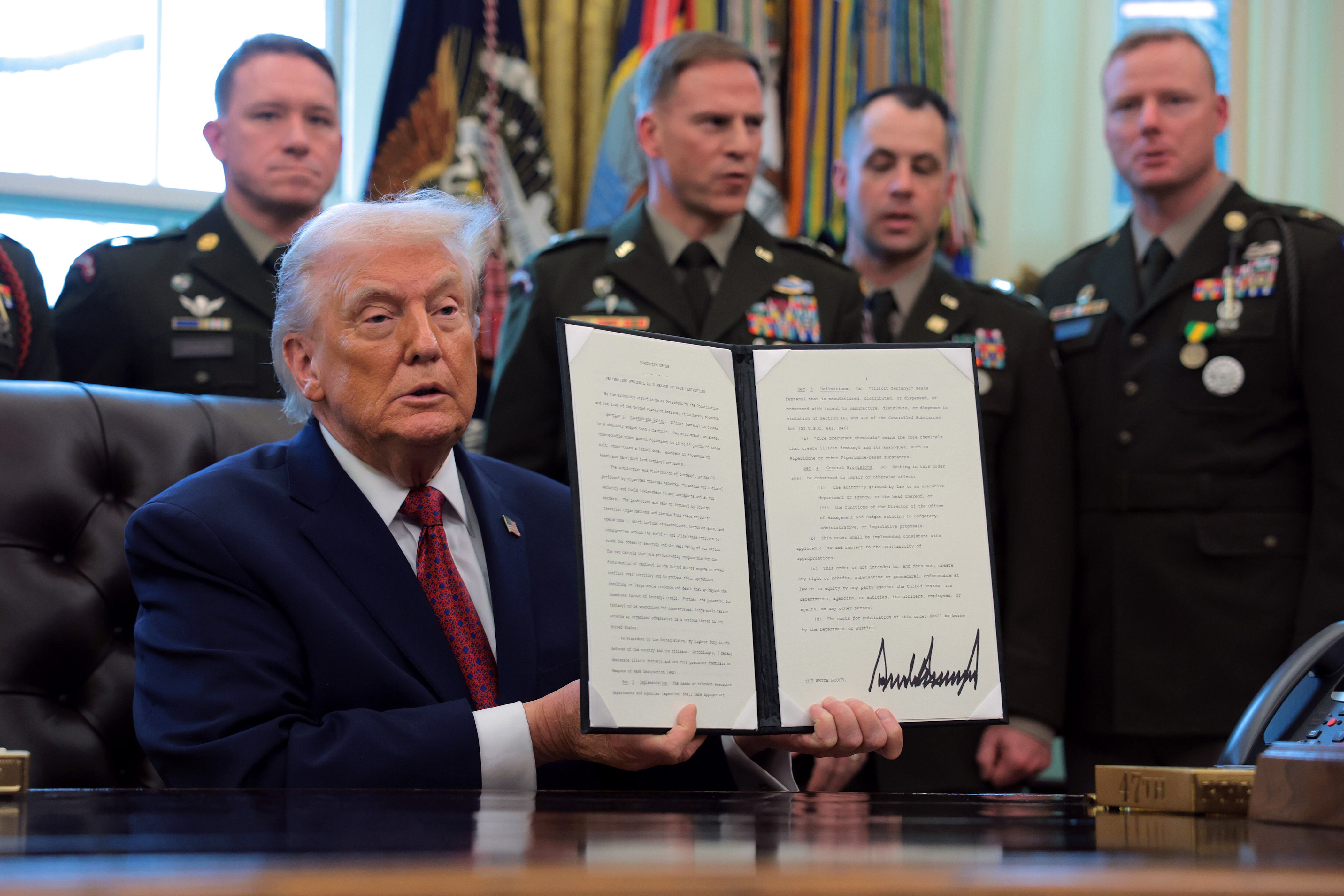 President Donald Trump holds up an executive order he signed to classify fentanyl a weapon of mass destruction during a ceremony to present the Mexican Border Defense Medal in the Oval Office of the White House on December 15, 2025. / Anna Moneymaker/Getty Images
