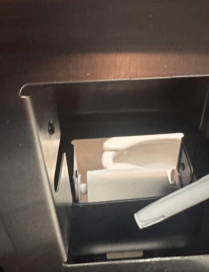Paper towel dispenser with a lever handle visible inside