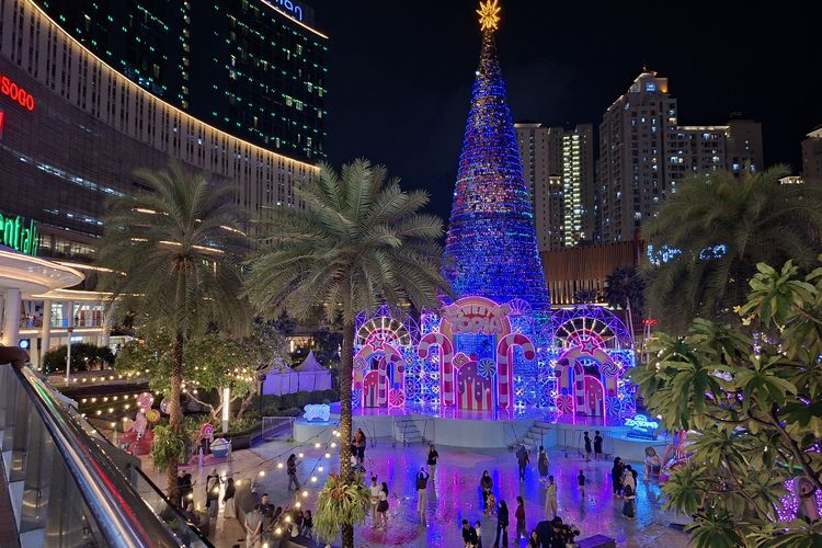 Di depan pohon Natal raksasa, ibu berdoa damai tahun depan