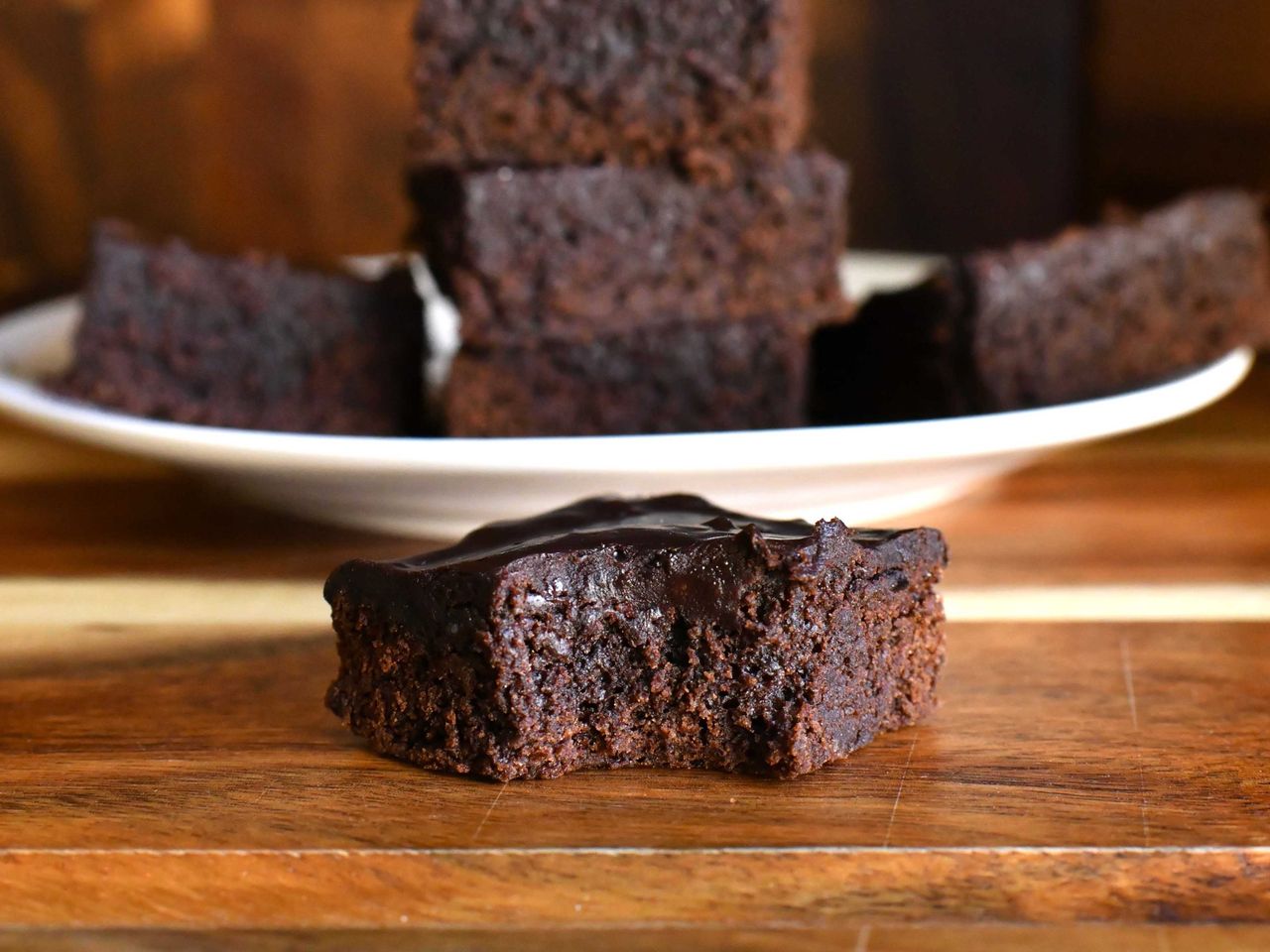 Brownie close up with a plate of brownies in the background