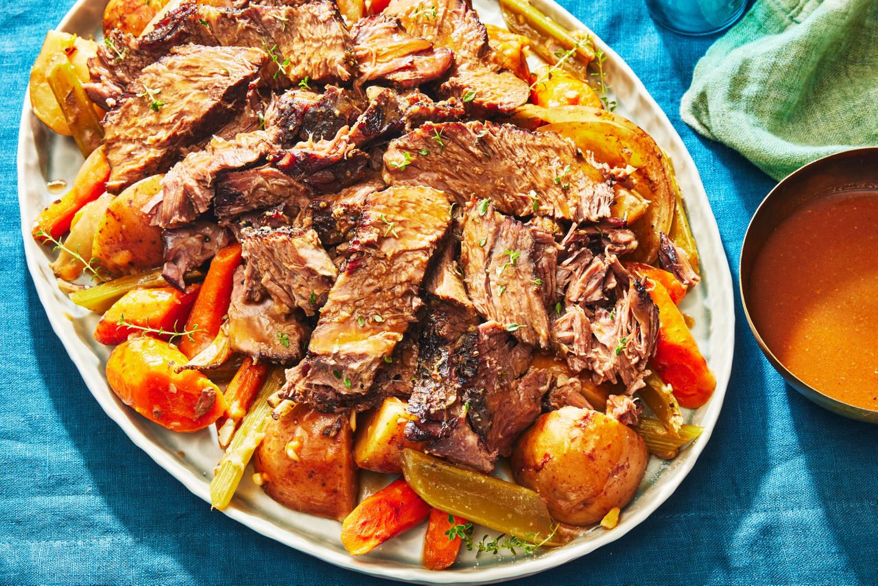 Slow-Cooker Pot Roast on a bed potatoes and carrots - Southern Living