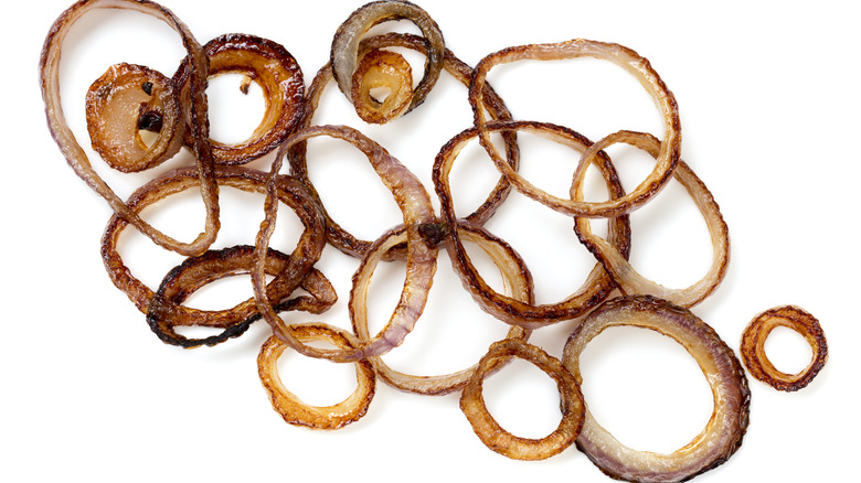 Grilled red onion rings on white background
