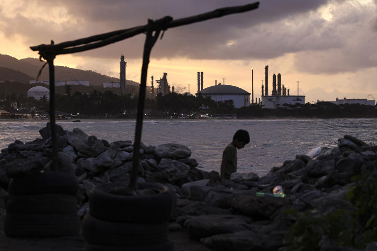 A child walks by the beach near a refinery in Puerto Cabello, Venezuela.
