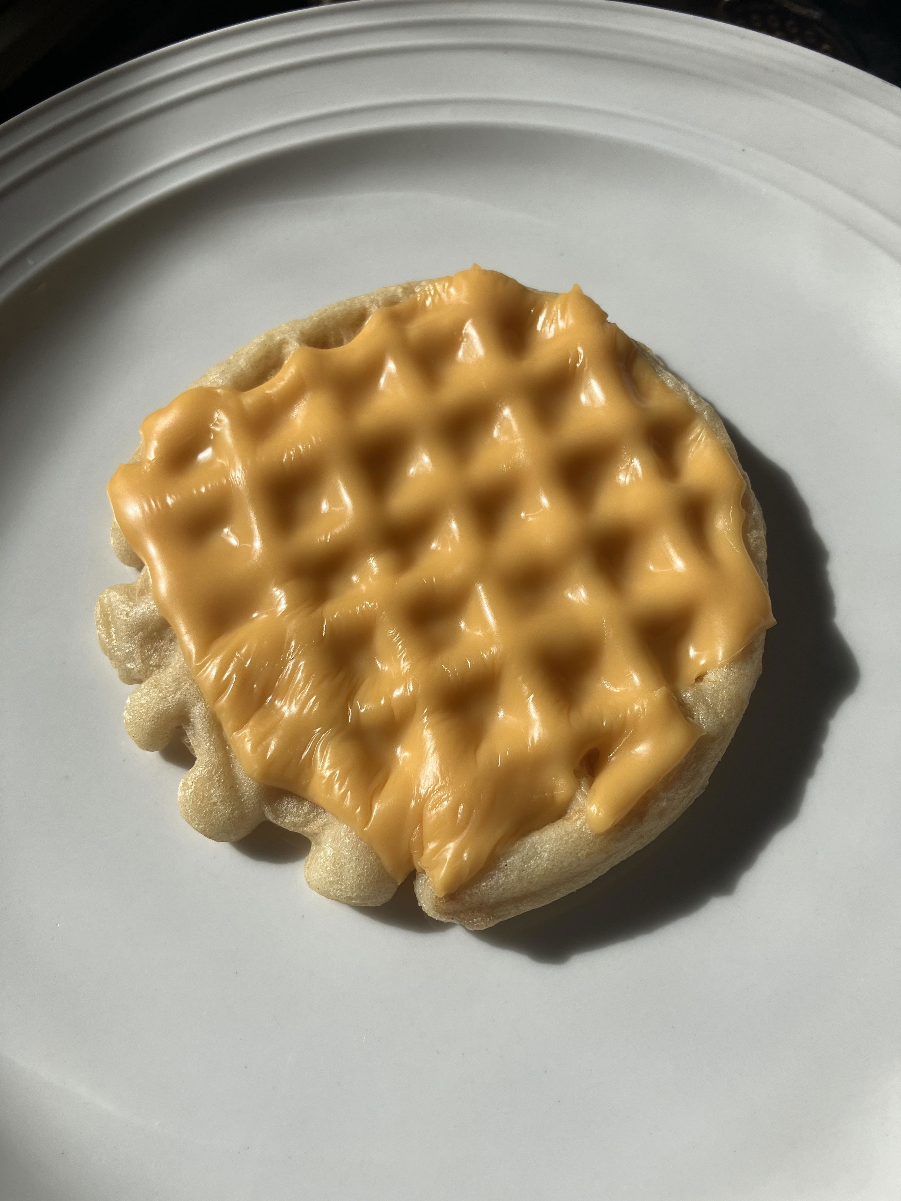 A single slice of cheese melted onto a frozen waffle