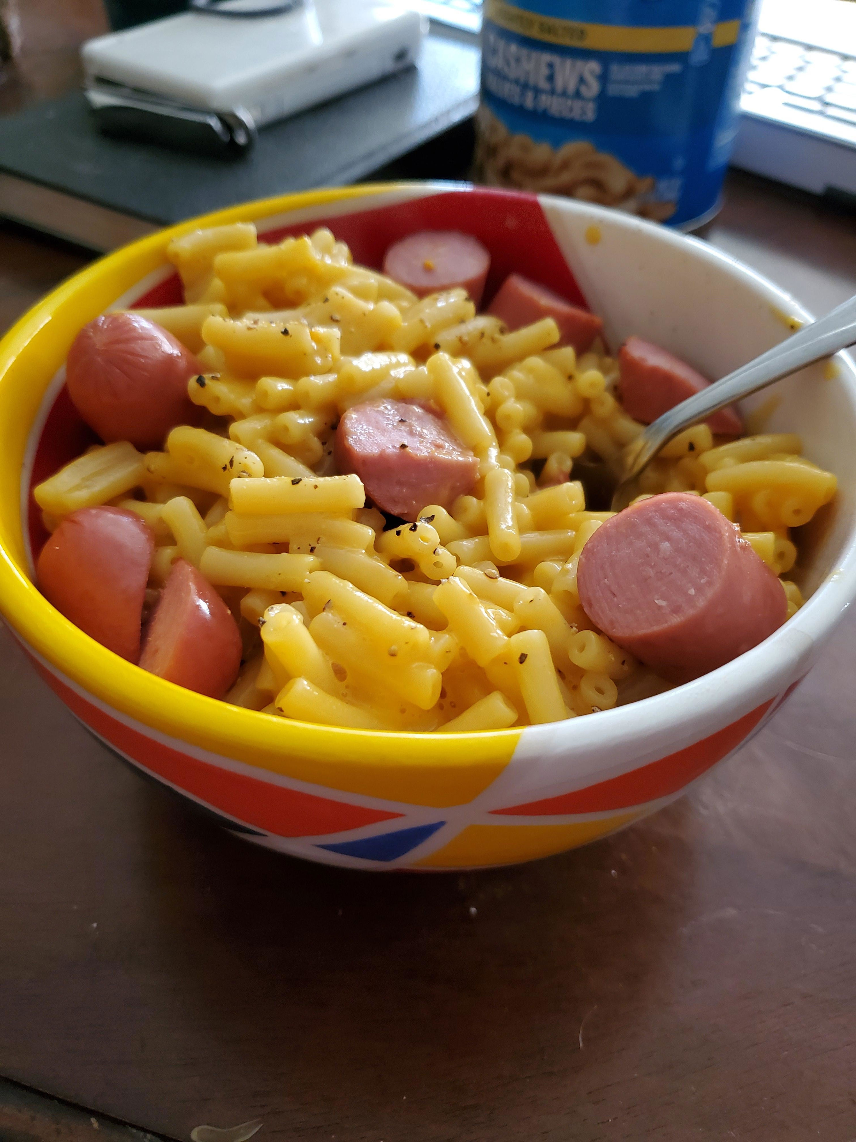 A bowl of boxed mac 'n' cheese with cut-up hot dogs