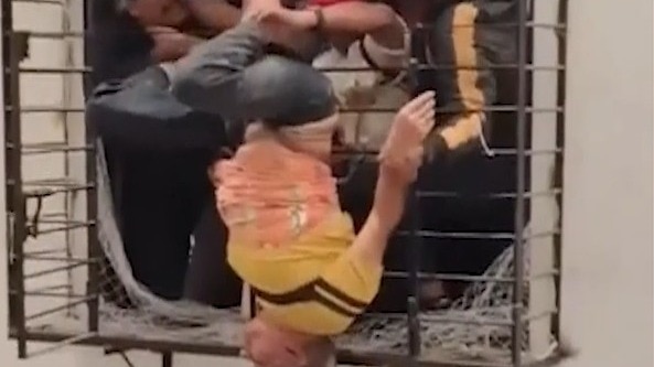 Man falls, dangles upside down from 8th floor window, video of rescue ...