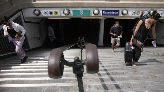 People exit a Metro station in Paris Thursday, July 20, 2023. Next year, public transport is again expected to play a starring role. Paris 2024 organizers are counting on spectators to rely overwhelmingly on the Paris region's dense network of Metro lines, suburban trains, buses and other transport to help the Games reach its target of halving its carbon footprint compared to previous editions.