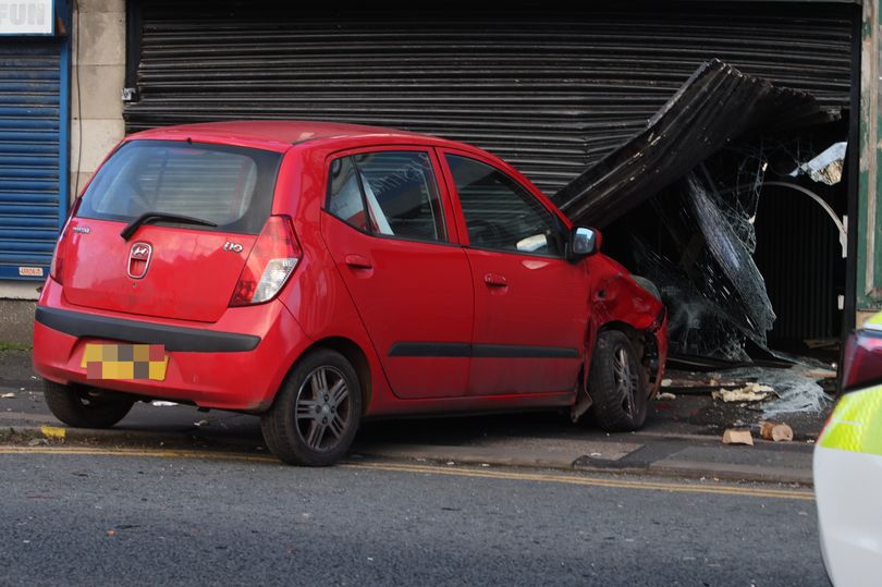 Woman rushed to hospital after car crashes into shopfront on Boxing Day