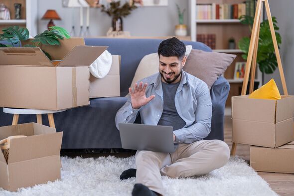 Man video calling on laptop celebrating new home