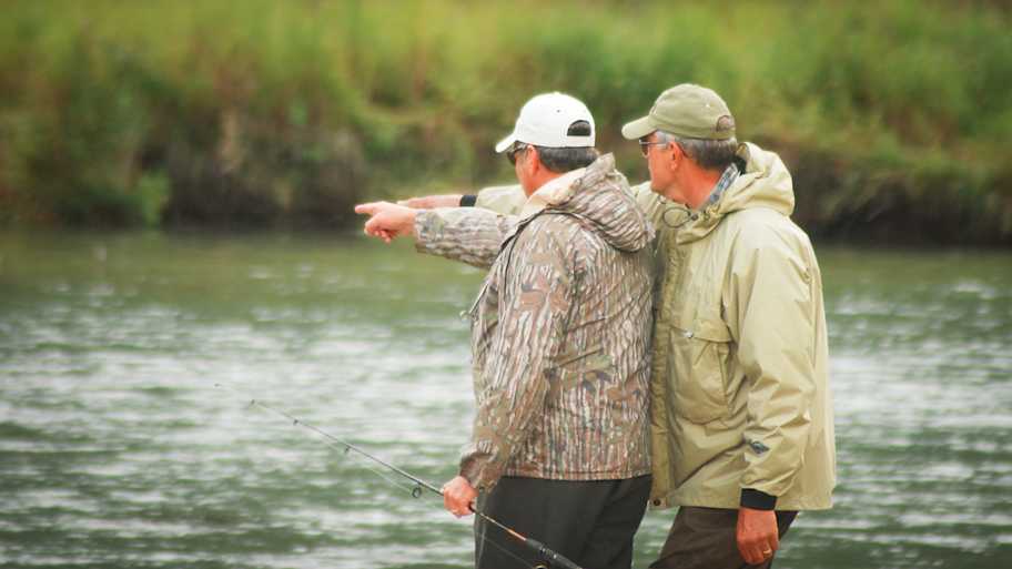 A fly fishing guide points out to his angler where the fish are.