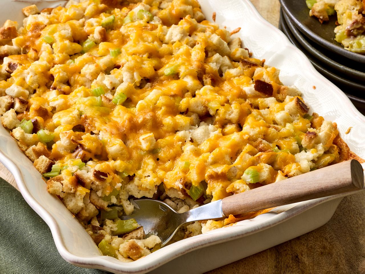 A dish containing chicken stuffing casserole with a serving spoon