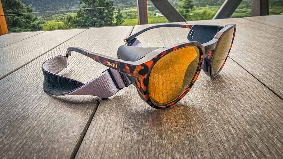 A pair of Smith Venture sunglasses resting on a picnic table looking over the green tundra of Alaska.