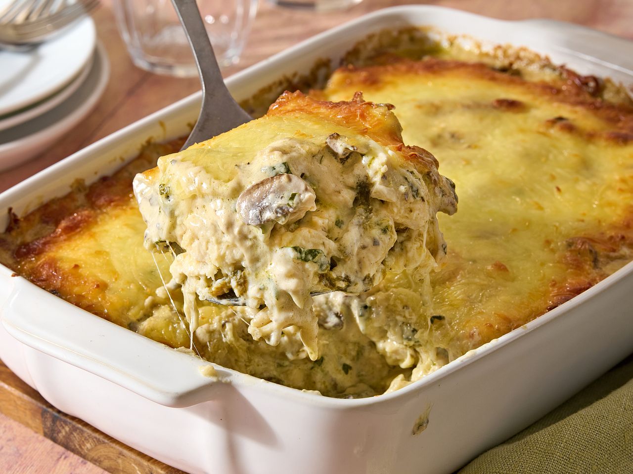 A serving of chicken enchilada casserole being lifted from a baking dish