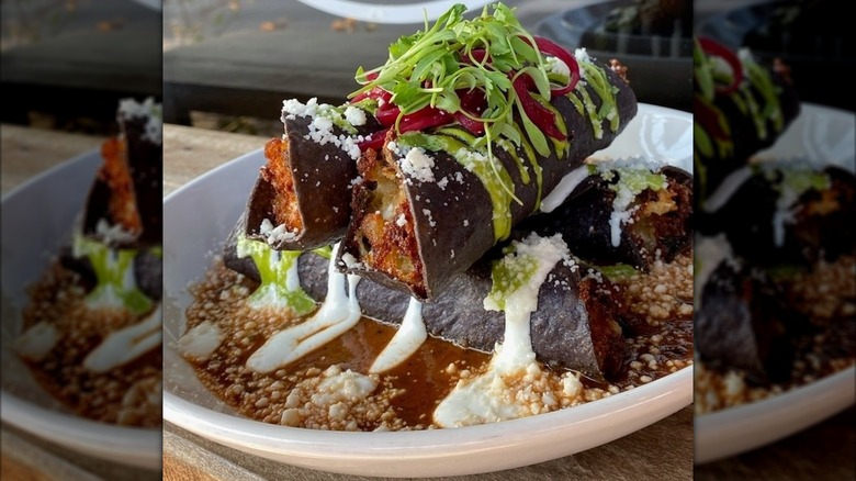Tacos dorado with fresh greens, crema, and cheese