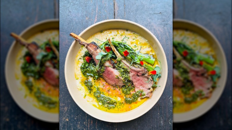 Lamb chops with salsa verde in bowl on wooden table