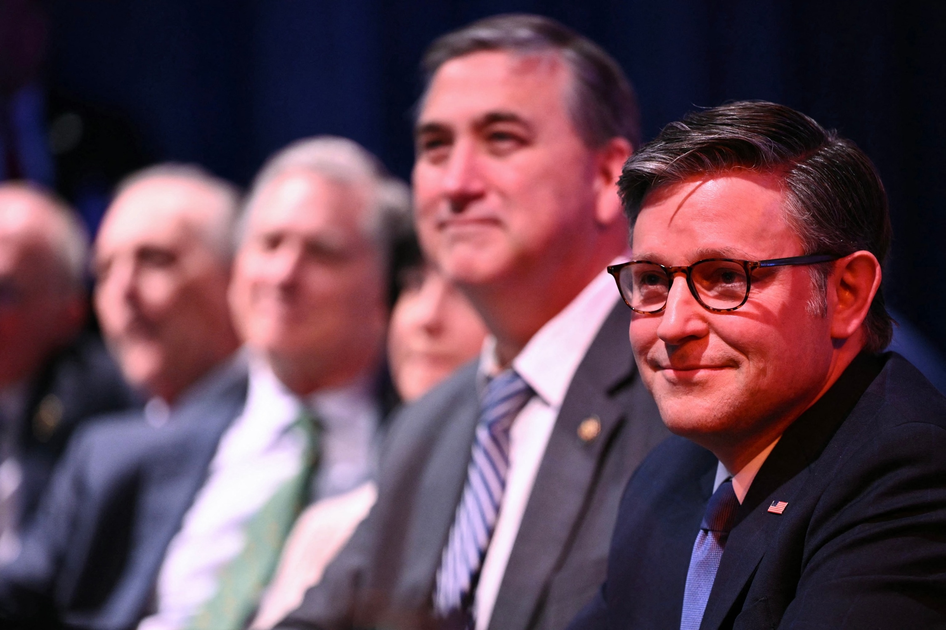 Mandel Ngan/AFP via Getty Images - PHOTO: Speaker of the House Mike Johnson listens as President Donald Trump speaks during the House Republican Party member retreat at the Kennedy Center in Washington, January 6, 2026.