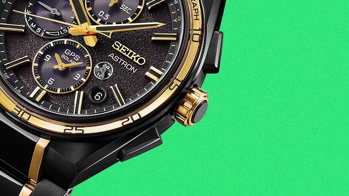 Close-up of a black and gold Seiko Astron GPS Solar watch face with textured dial and multiple subdials.