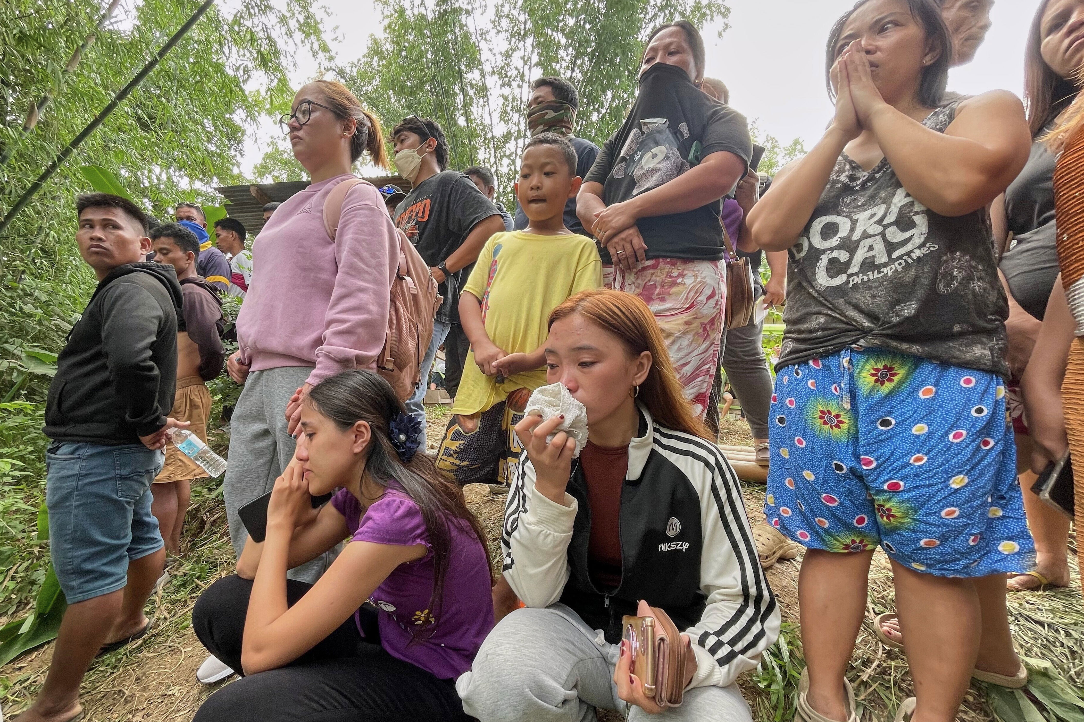 Relatives wait for news after a mound of garbage collapsed in Binaliw, Cebu city, on 9 January 2026 (AP)
