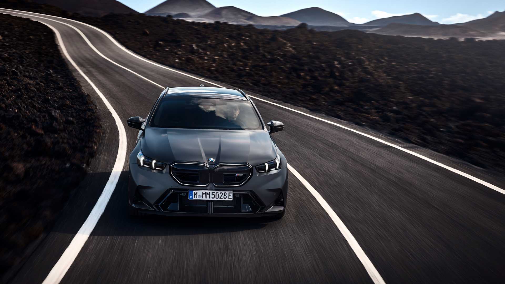 2025 BMW M5 Touring in gray driving down mountain road