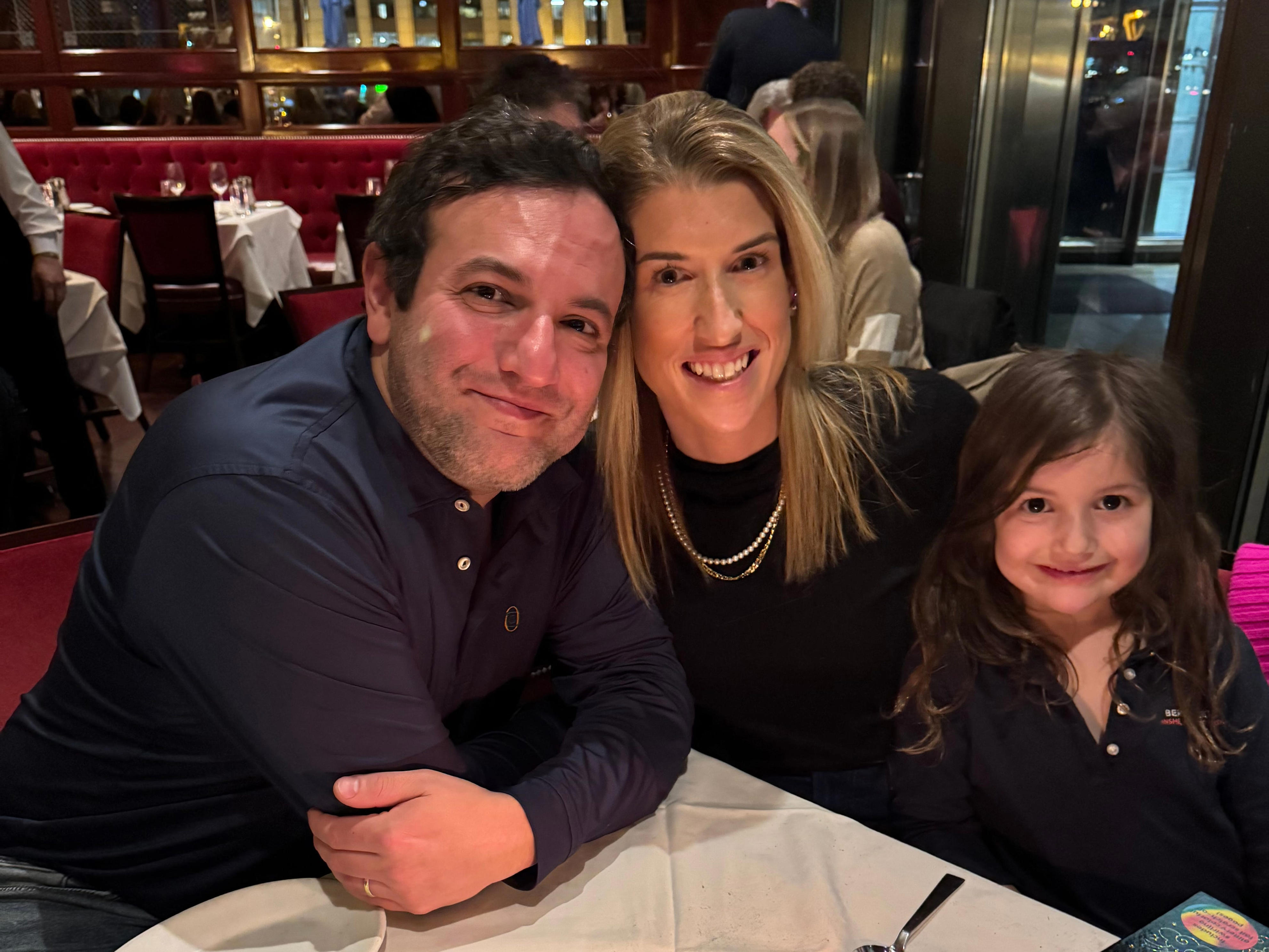 Camille Seigle is pictured with her husband and daughter celebrating a birthday at a restaurant.