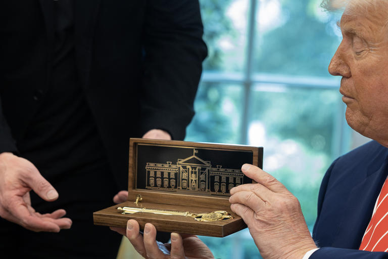 President Donald Trump presents Elon Musk a key to the White House on May 30, in the Oval Office.