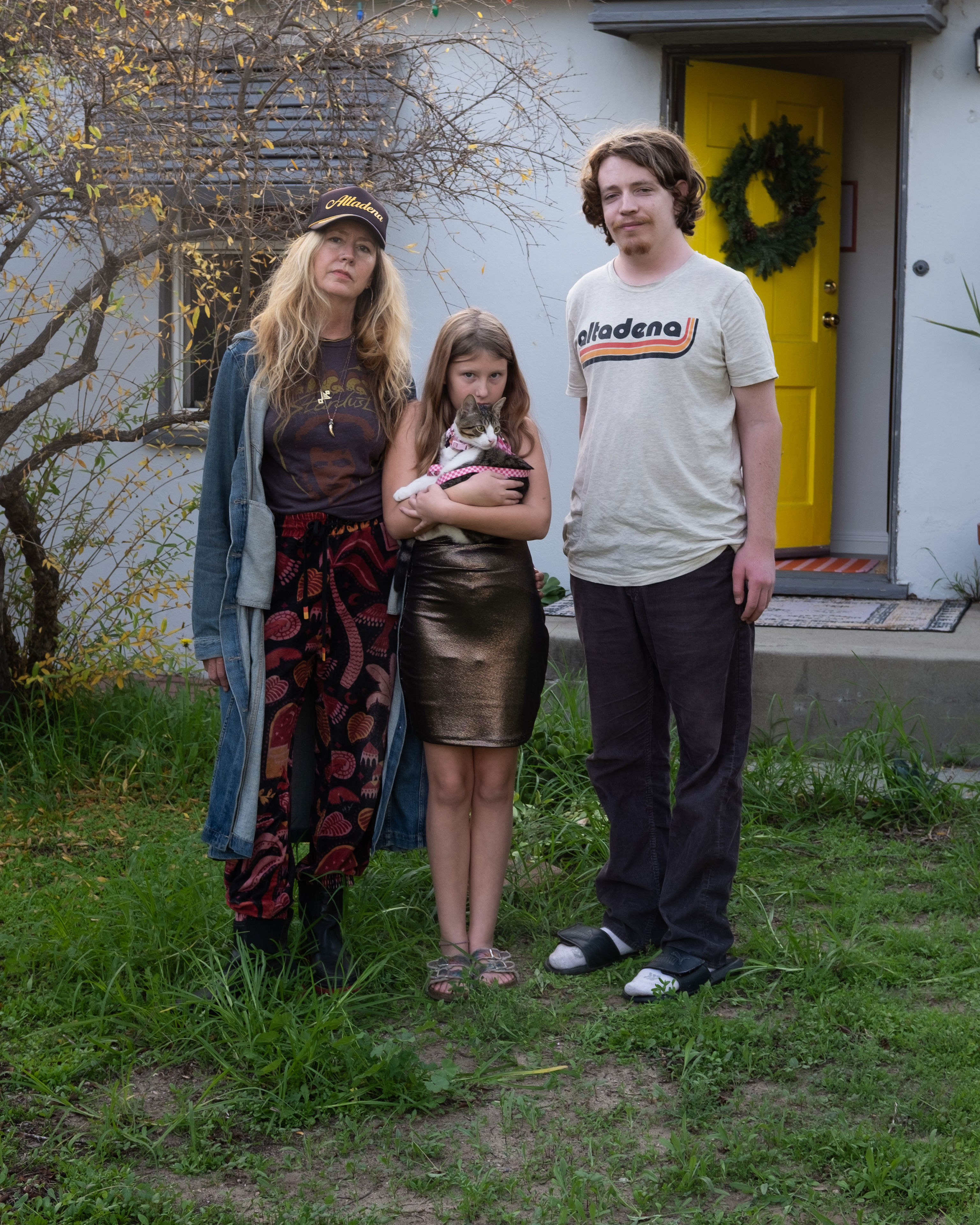 De izquierda a derecha, Leigh McDaniel, de 57 años, su hija, Luna Rae Bozeman, de 10 años, y su hijo, Seamus Bozeman, de 23 años, frente a su casa en Pasadena.