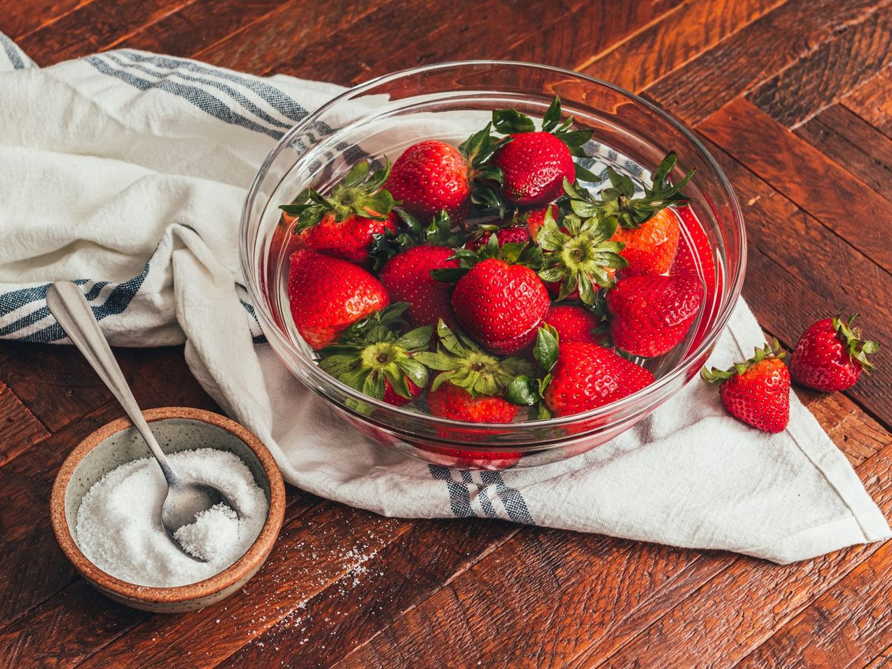 a bowl of strawberries in water with salt