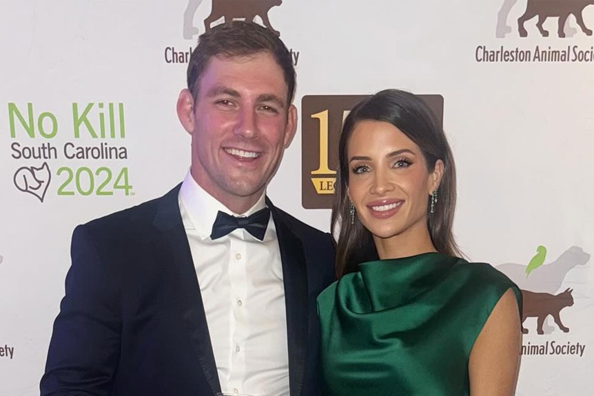 Naomie Olindo and Billy Haire posing together in front of a step and repeat.