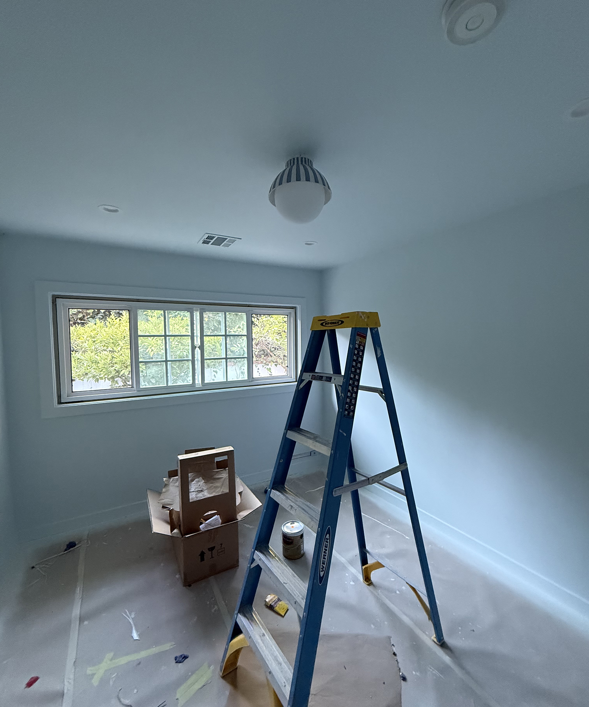 bedroom having just been painted with a stepladder in the middle