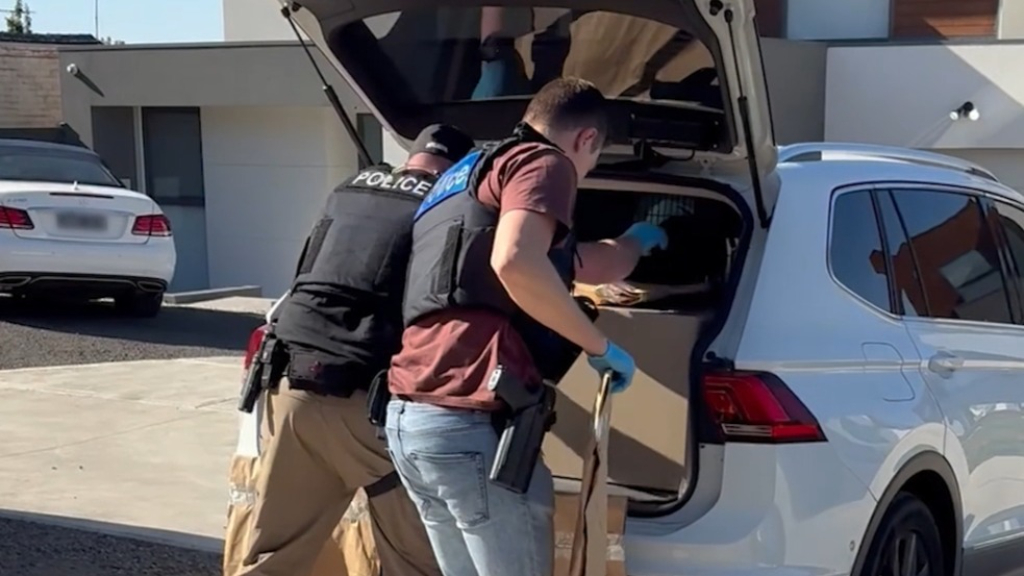 Two charged after semi-automatic guns, drugs found in Melbourne home