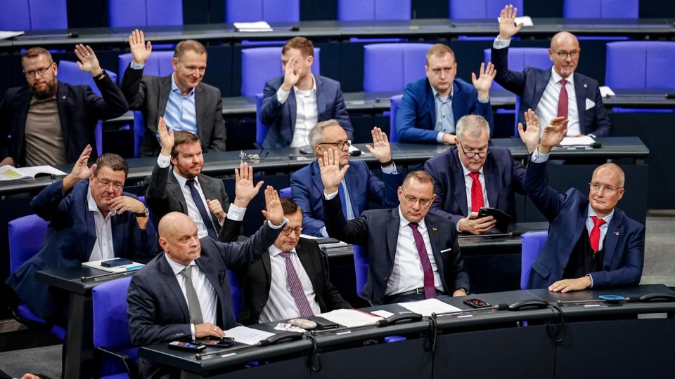 Alternative for Germany MPs with Tino Chrupalla (front, second from right), AfD federal and parliamentary group leader, raise their hands for a vote in the plenary chamber of the Bundestag on December 19, 2025, in Berlin. - Kay Nietfeld/Picture Alliance/dpa/Getty Images