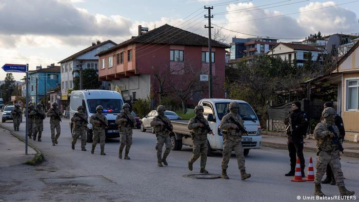 Turkish police vehicles and officers blocking a road near the operation site in Elmalik village, Yalova