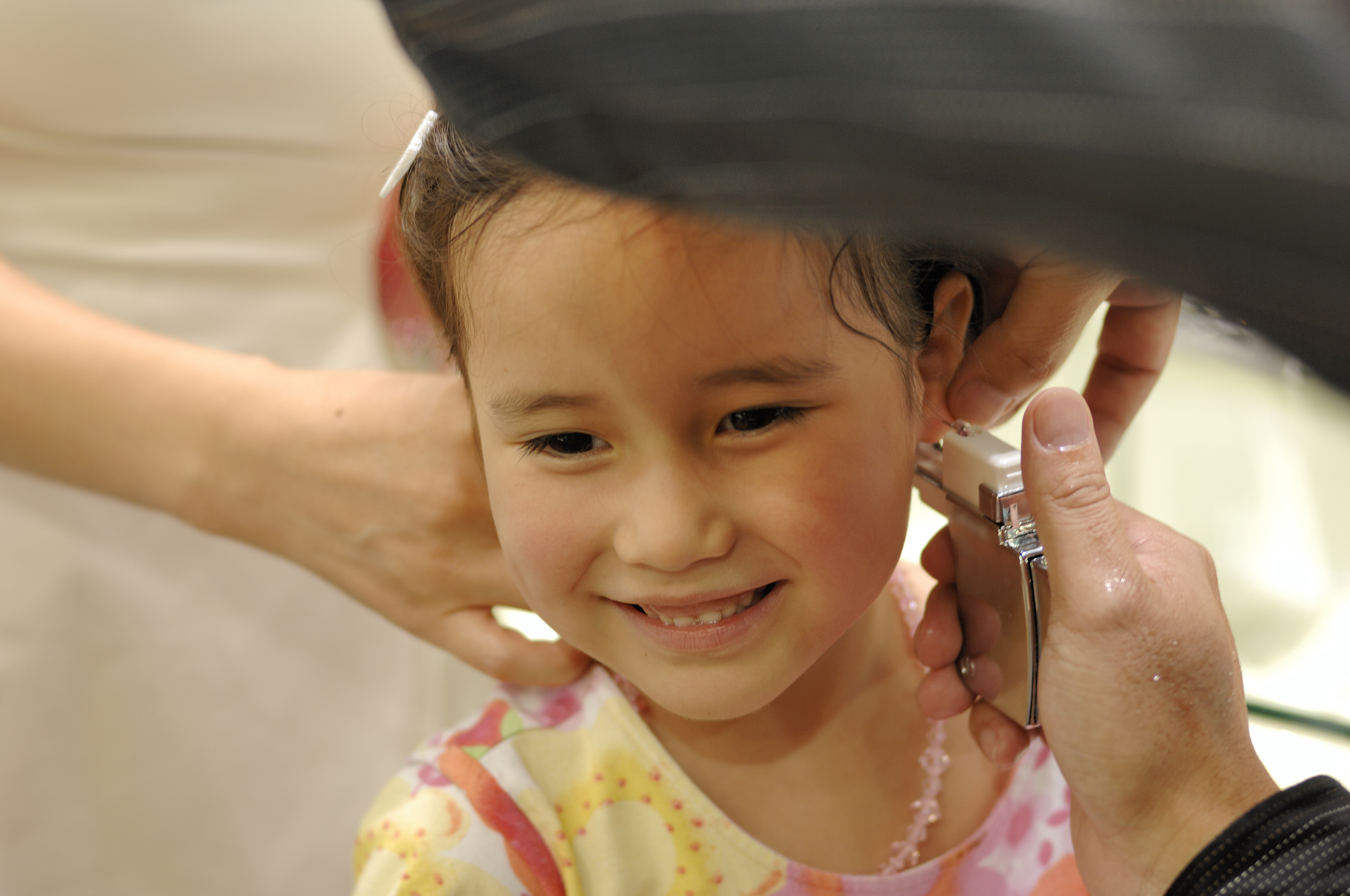 A little girl is getting her ears pierced