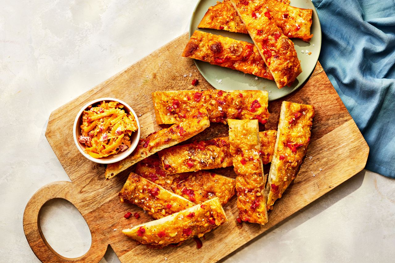Southern Living Pimento Cheese Flatbread on a board to serve with extra pimento cheese