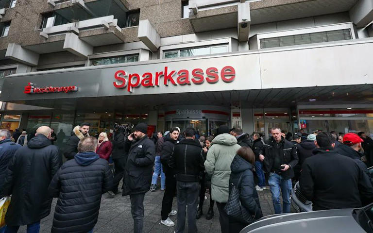 People protest outside the Sparkasse branch that was robbed