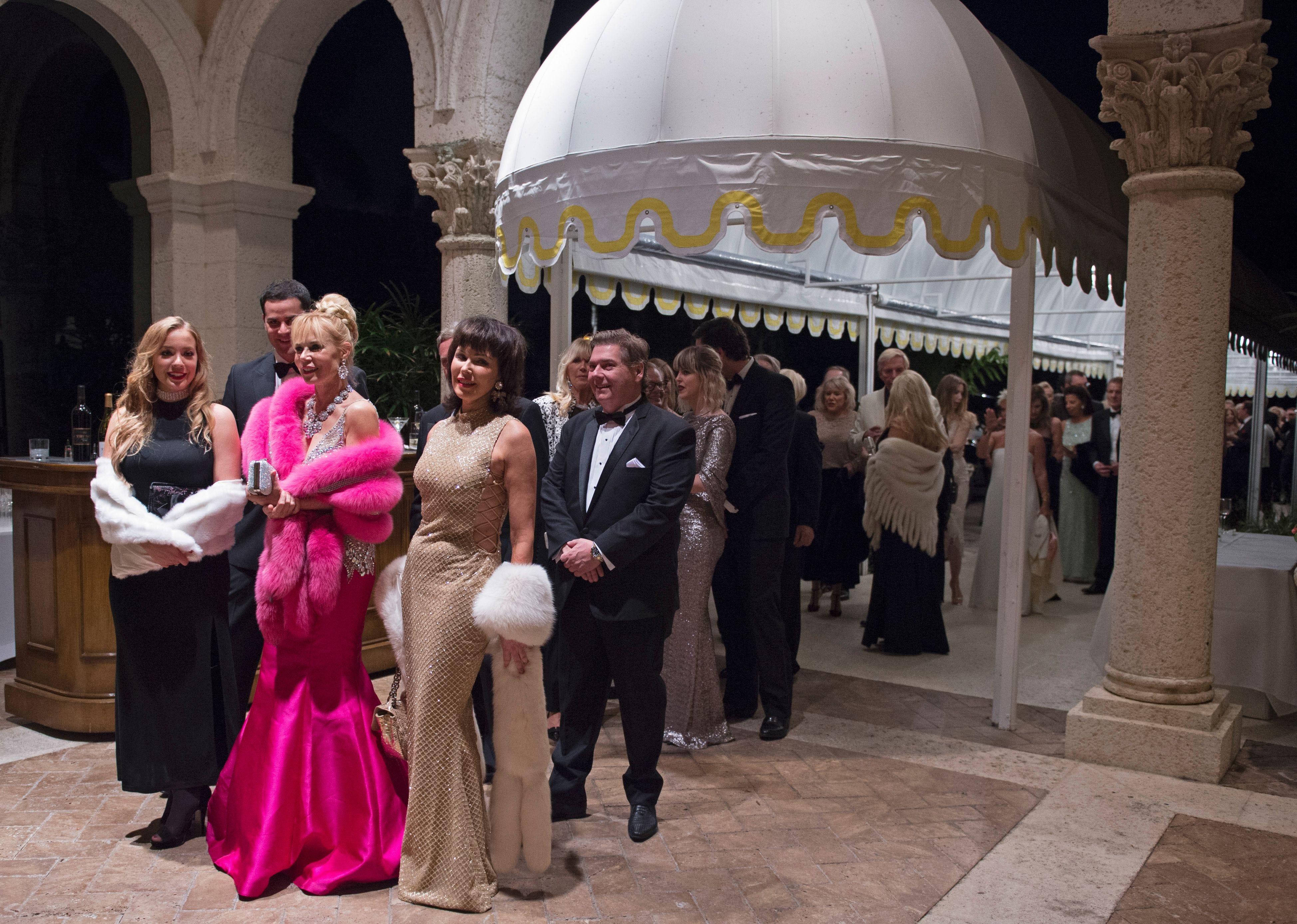 Party goers line up to enter then US President-elect Donald Trump's New Year's Eve party December 31, 2016 at Mar-a-Lago in Palm Beach, Florida.