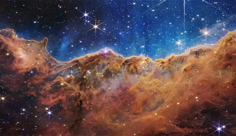Esta imagem, uma das primeiras captadas pelo Telescópio Espacial James Webb, mostra a nebulosa Carina no meio de um campo polvilhado com estrelas.