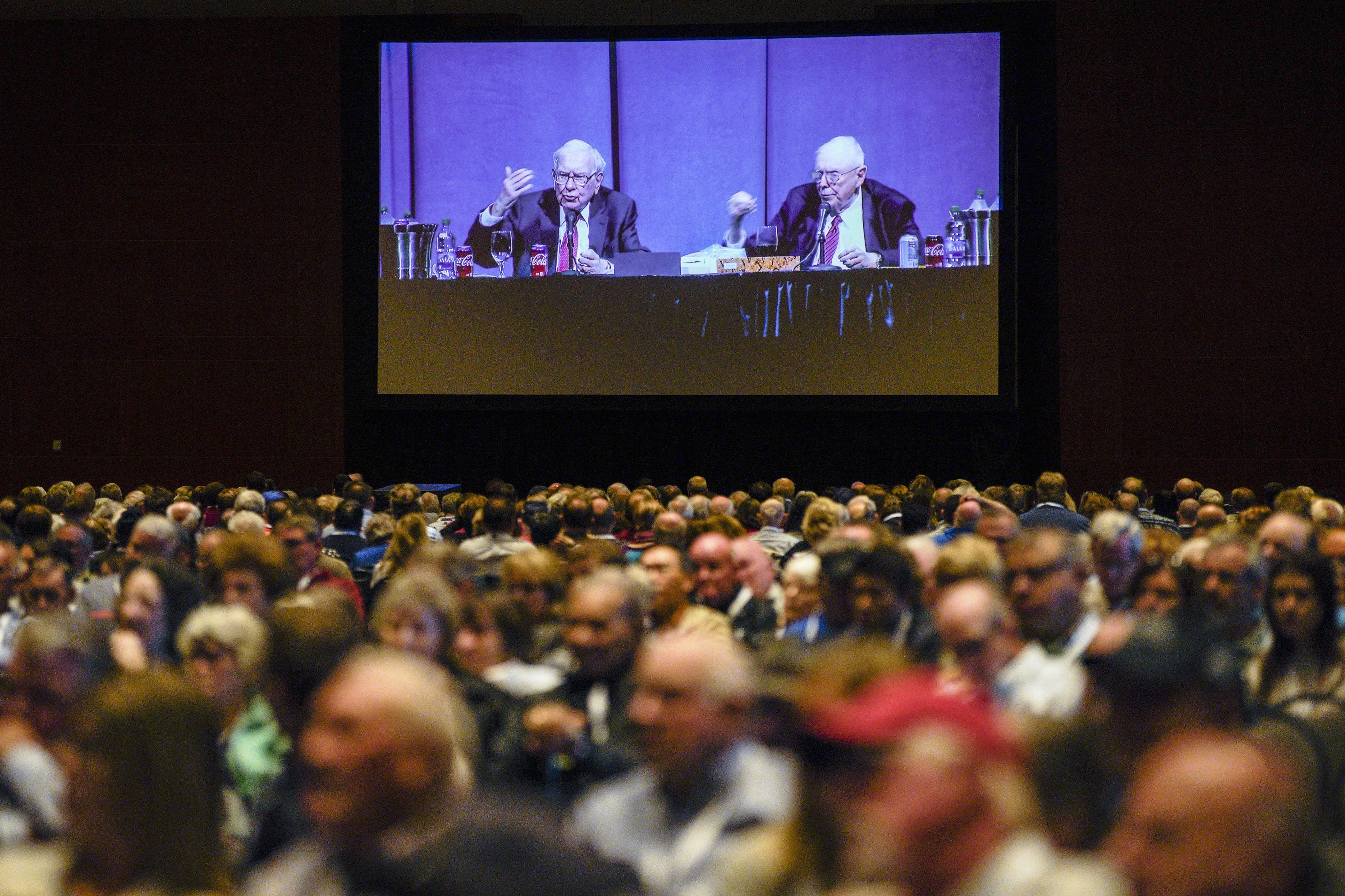 Shareholders in overflow rooms watch on big screens as Berkshire Hathaway Chairman and CEO Warren Buffett, left, and Vice Chairman Charlie Munger preside over the annual Berkshire Hathaway shareholders meeting in Omaha, Neb., Saturday, May 4, 2019. (AP Photo/Nati Harnik)