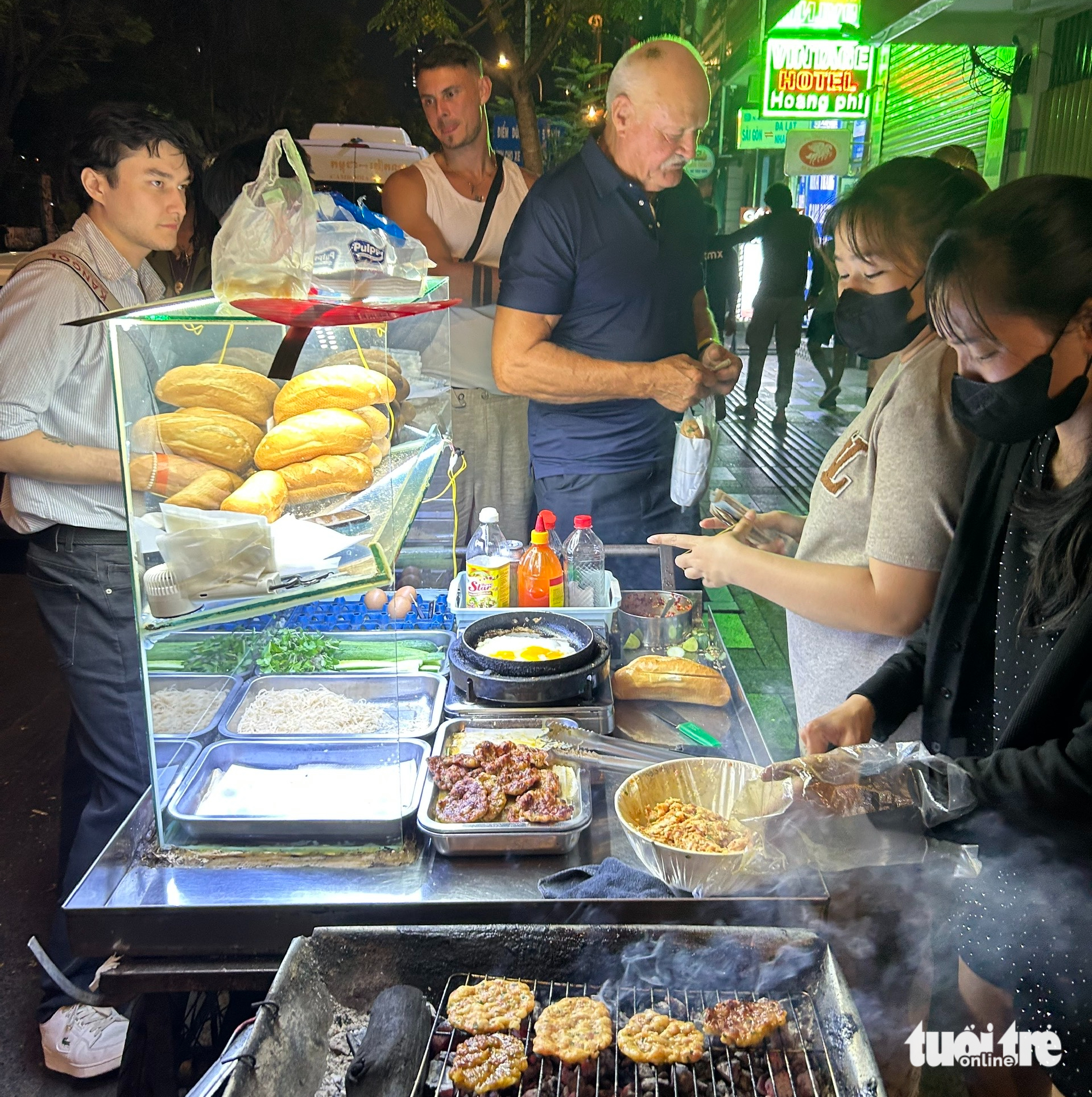 Du khách xếp hàng mua bánh mì ở khu phố Tây Bùi Viện rạng sáng đầu năm - Ảnh: T.T.D.