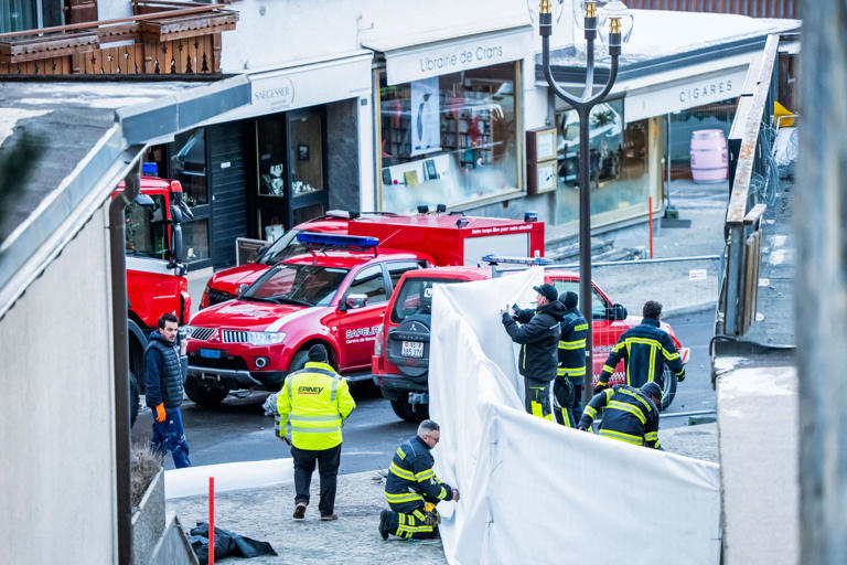Rescuers are seen on the site of a fire that ripped through a bar in the luxury Alpine ski resort town of Crans Montana, on January 1, 2026. / MAXIME SCHMID / AFP via Getty Images
