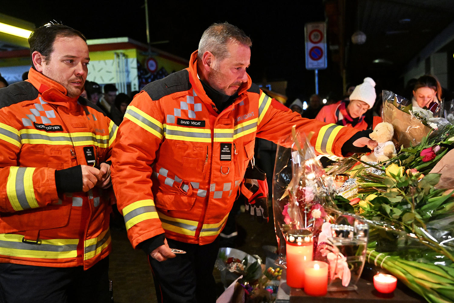 Firefighters gather to leave flowers and candles at the scene on Thursday. (Harold Cunningham / Getty Images)